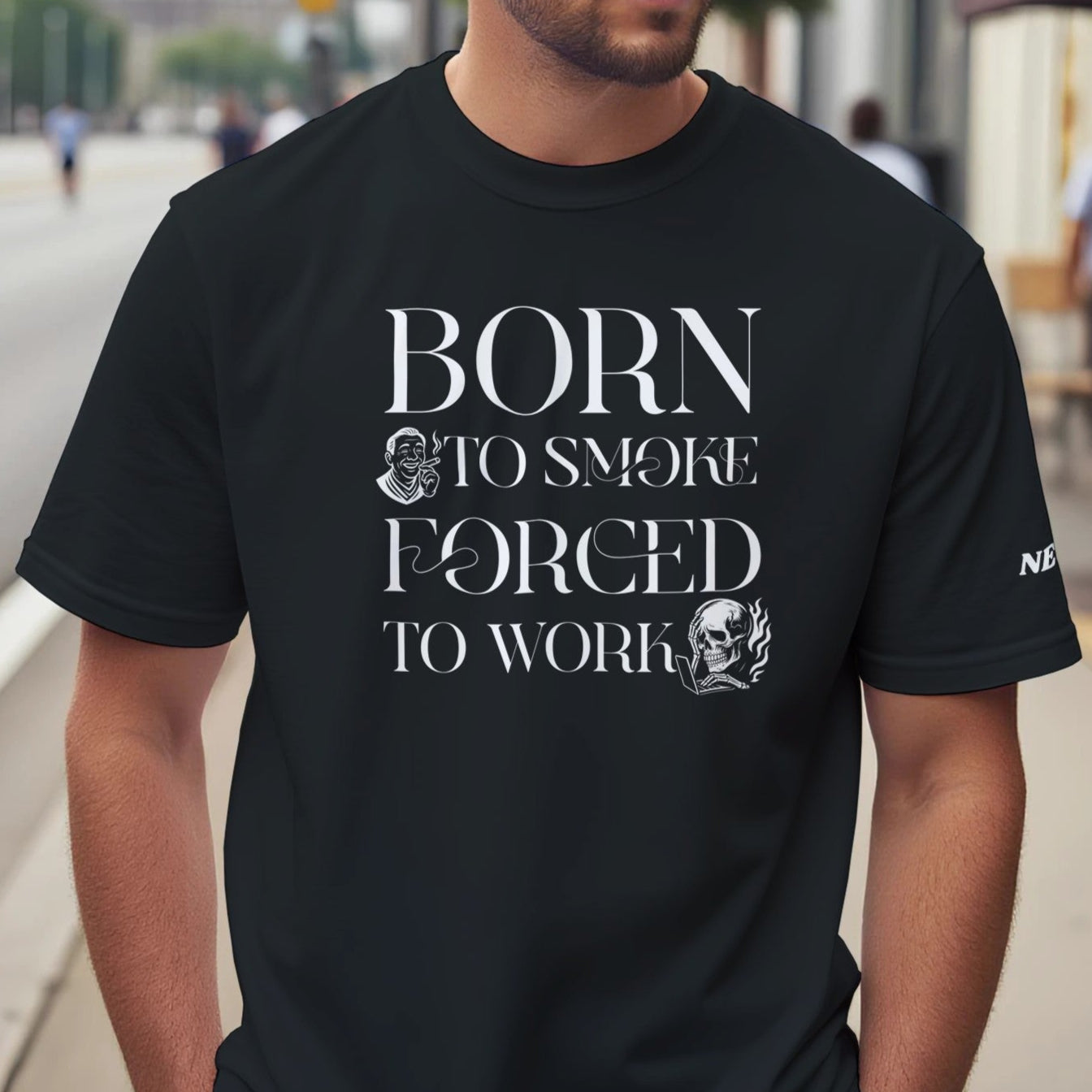 Man wearing a black t-shirt with text 'BORN TO SMOKE FORCED TO WORK' on a city street