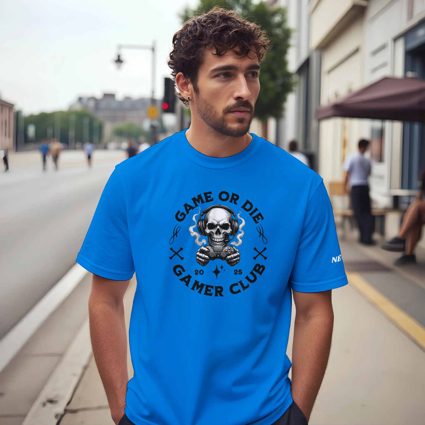 Man wearing a blue t-shirt with a skull graphic and text on a city street.