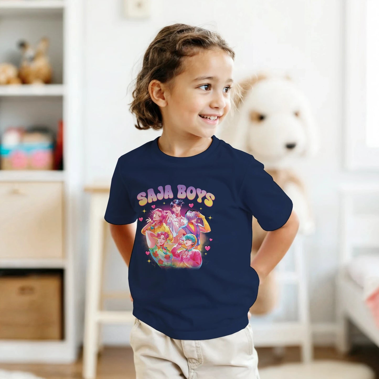Child wearing a navy blue t-shirt with colorful graphic and text in a room.