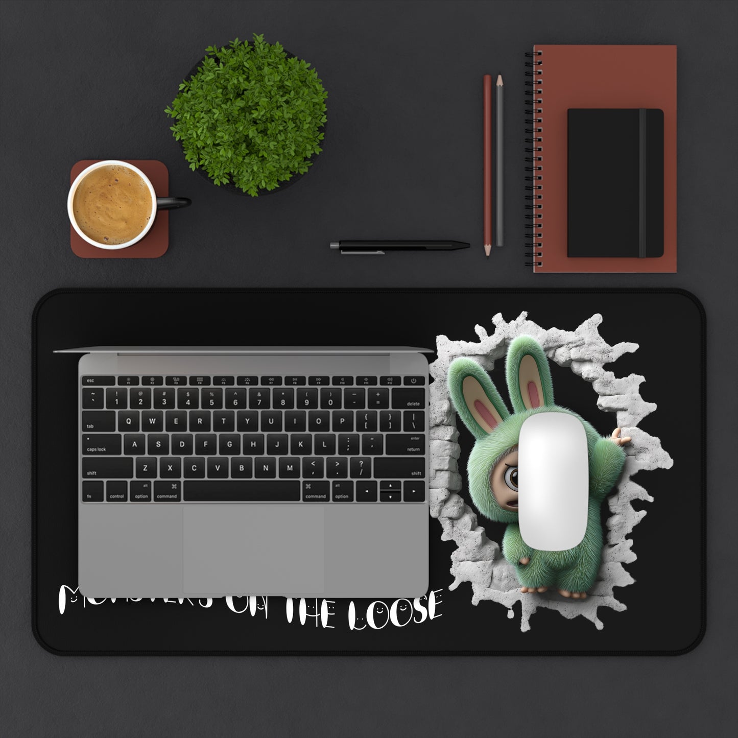 Laptop on a desk with a green labubu monster character and text 'Monsters on the Loose' on a black background.