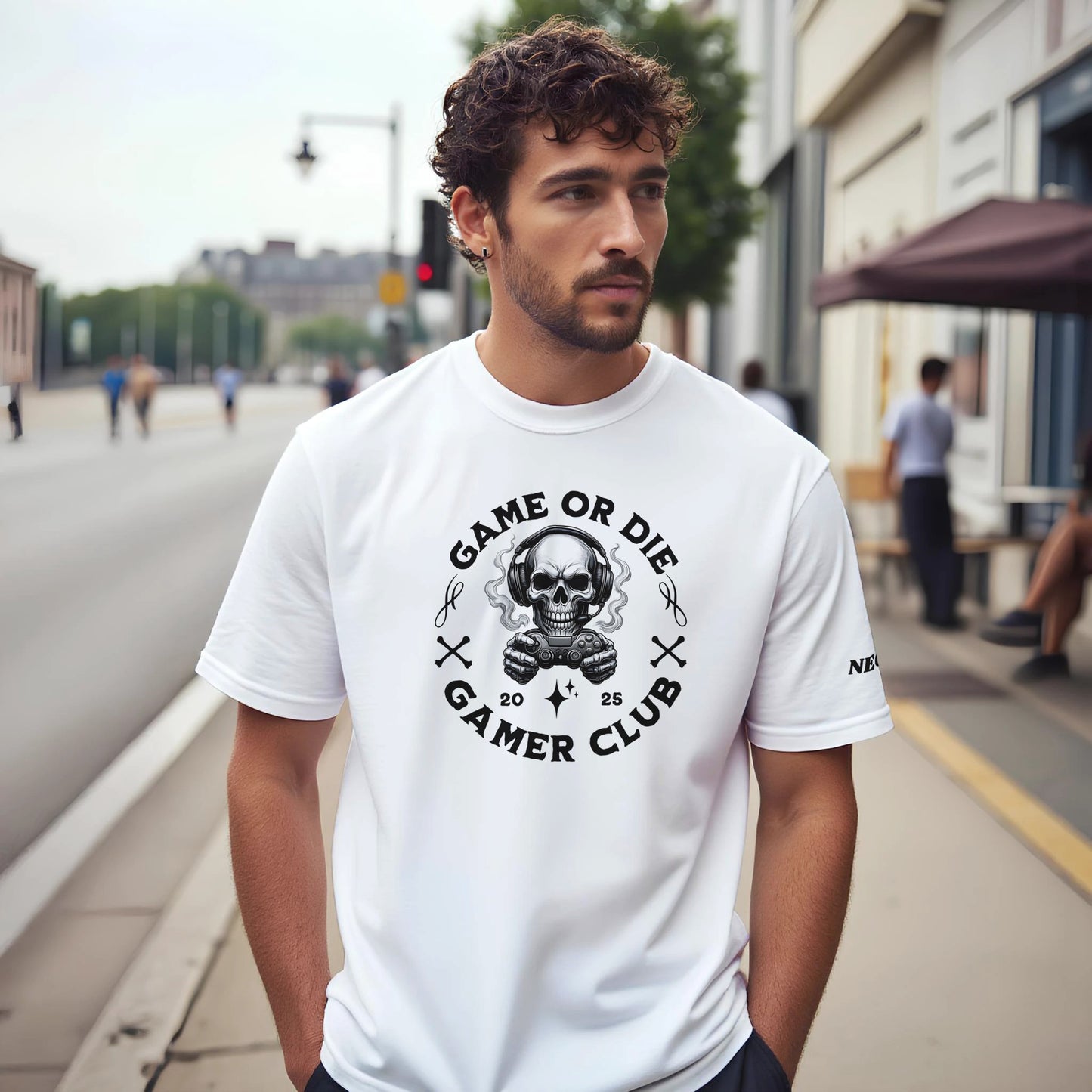 Man wearing a white t-shirt with a graphic design of a skull and text game or die gamer club, on a city street