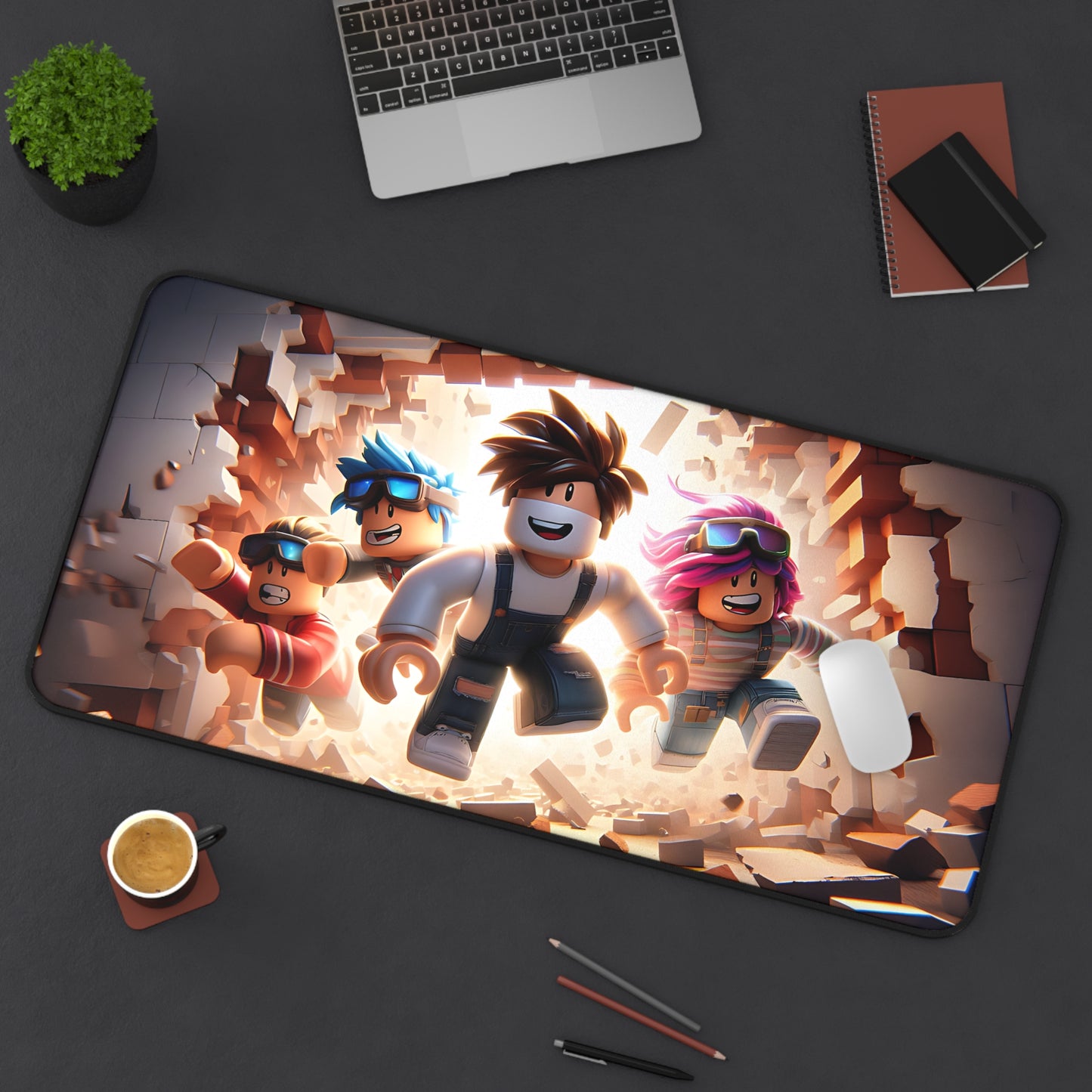 Desk setup with a large mouse pad featuring animated characters, a laptop, phone, and other items on a dark surface.