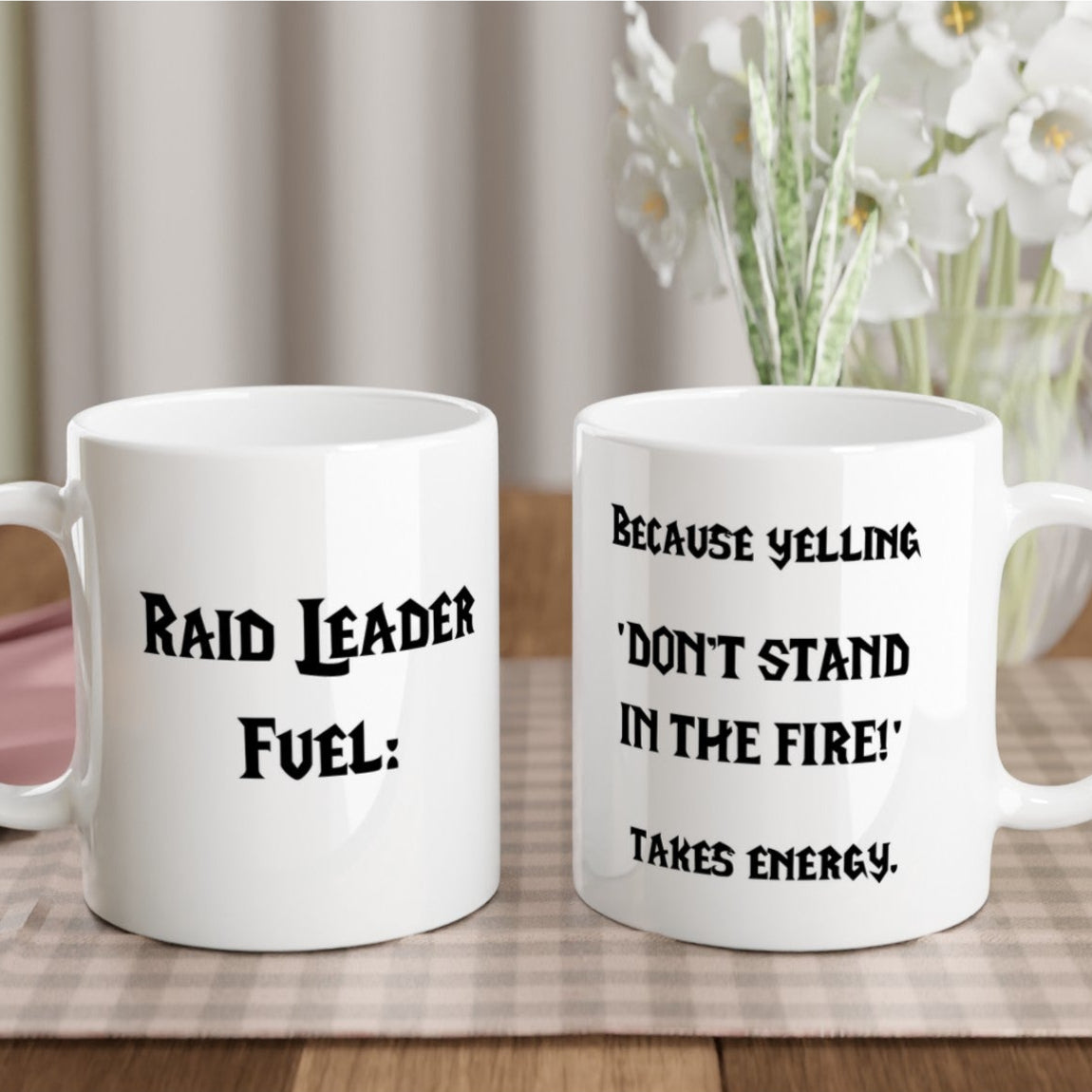 Raid Leader Mug, both sides view, placed on the table with flowers in the background