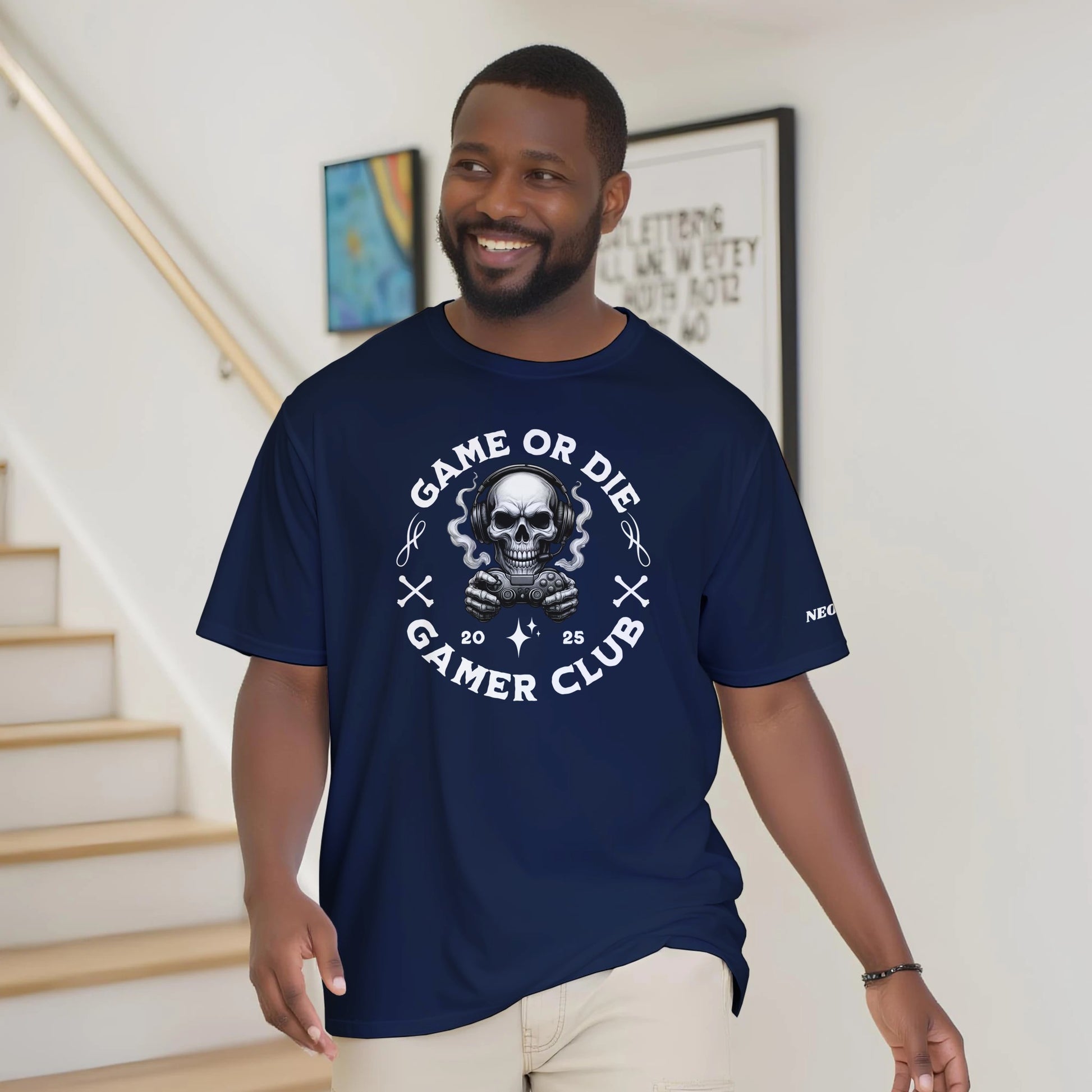 Man wearing a navy blue t-shirt with a skull graphic and text, standing indoors.