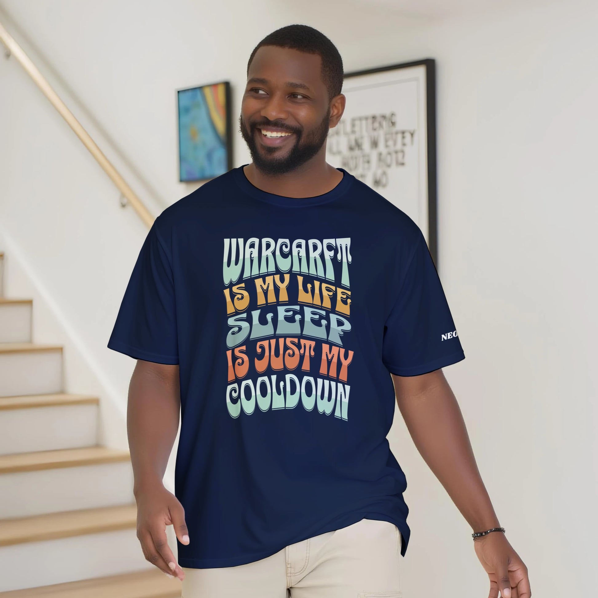 Man wearing a navy blue t-shirt with colorful text in a home setting