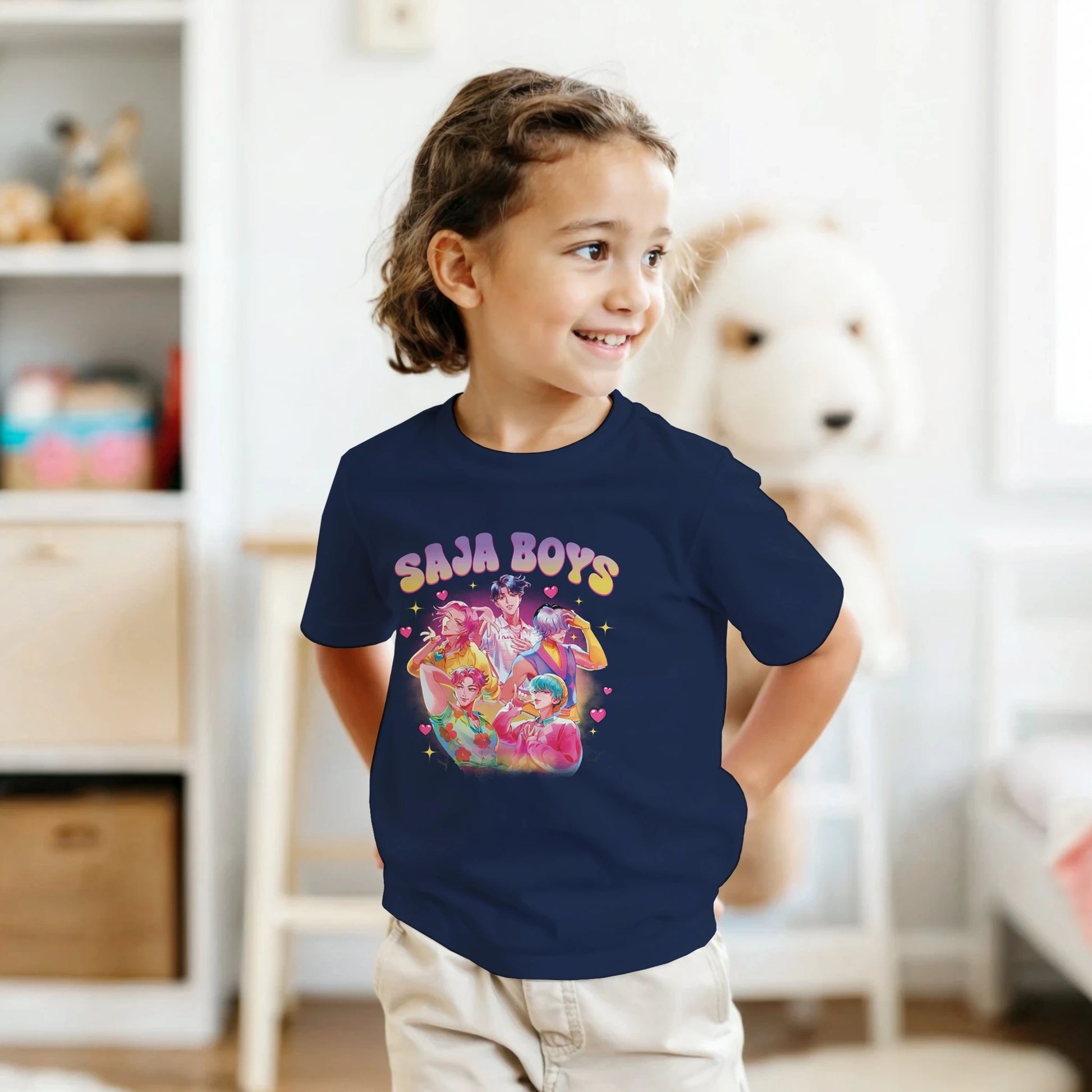 Child wearing a navy blue t-shirt with colorful graphic and text in a room.