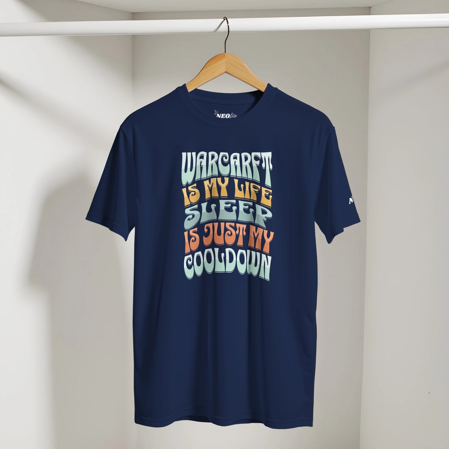 Navy blue t-shirt with colorful text on a hanger against a white wall