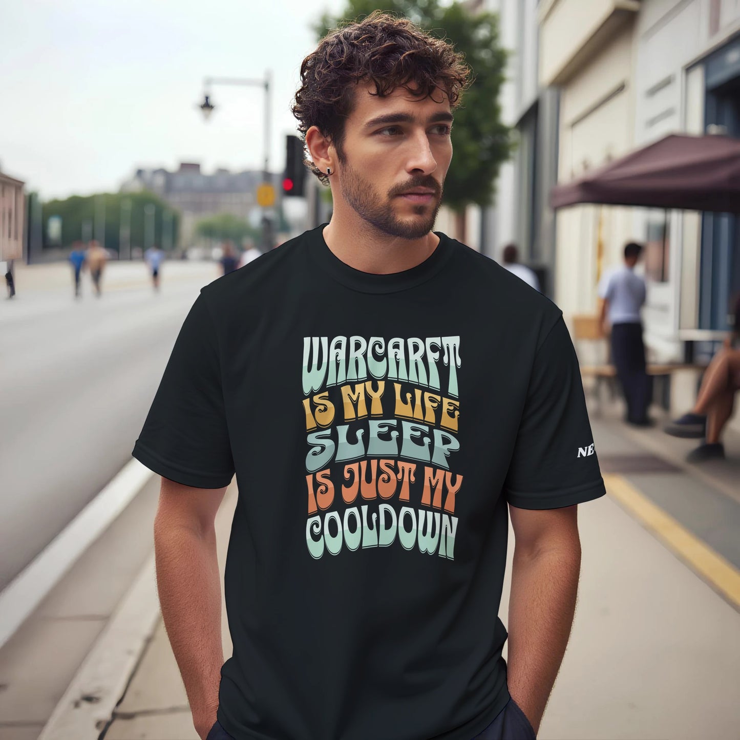 Man wearing a black t-shirt with colorful text on a city street
