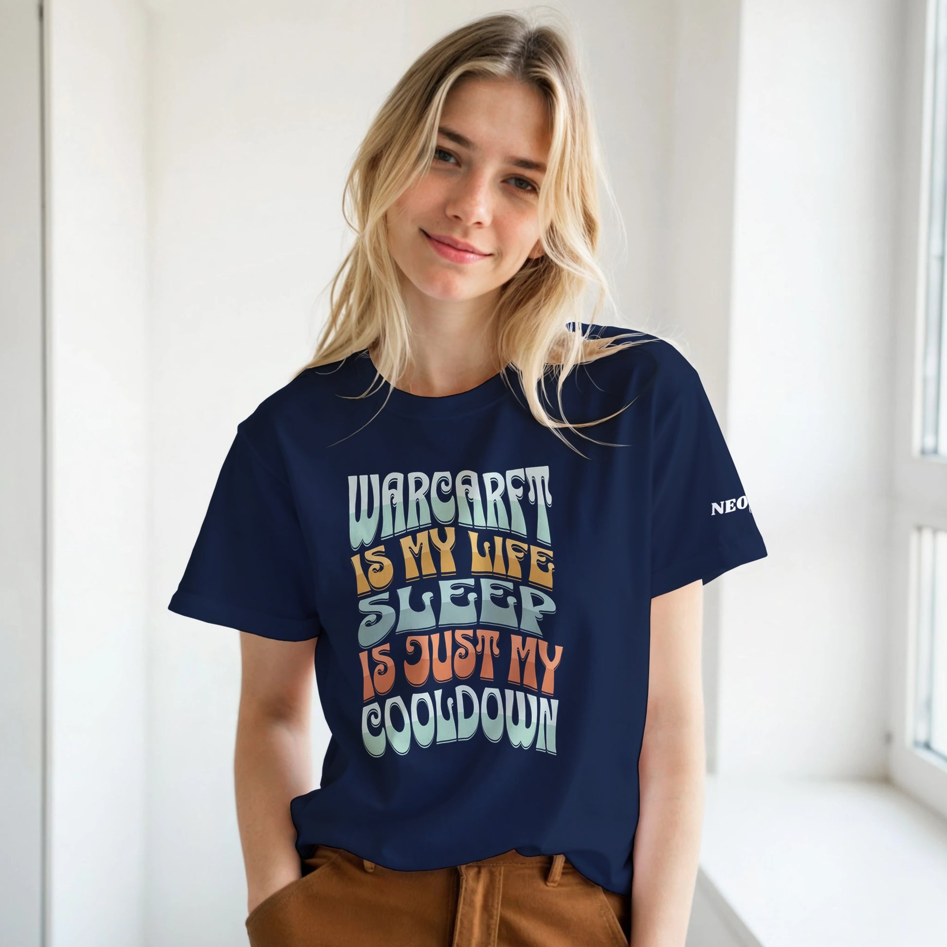 woman wearing a navy blue t-shirt with colorful text design, standing indoors.