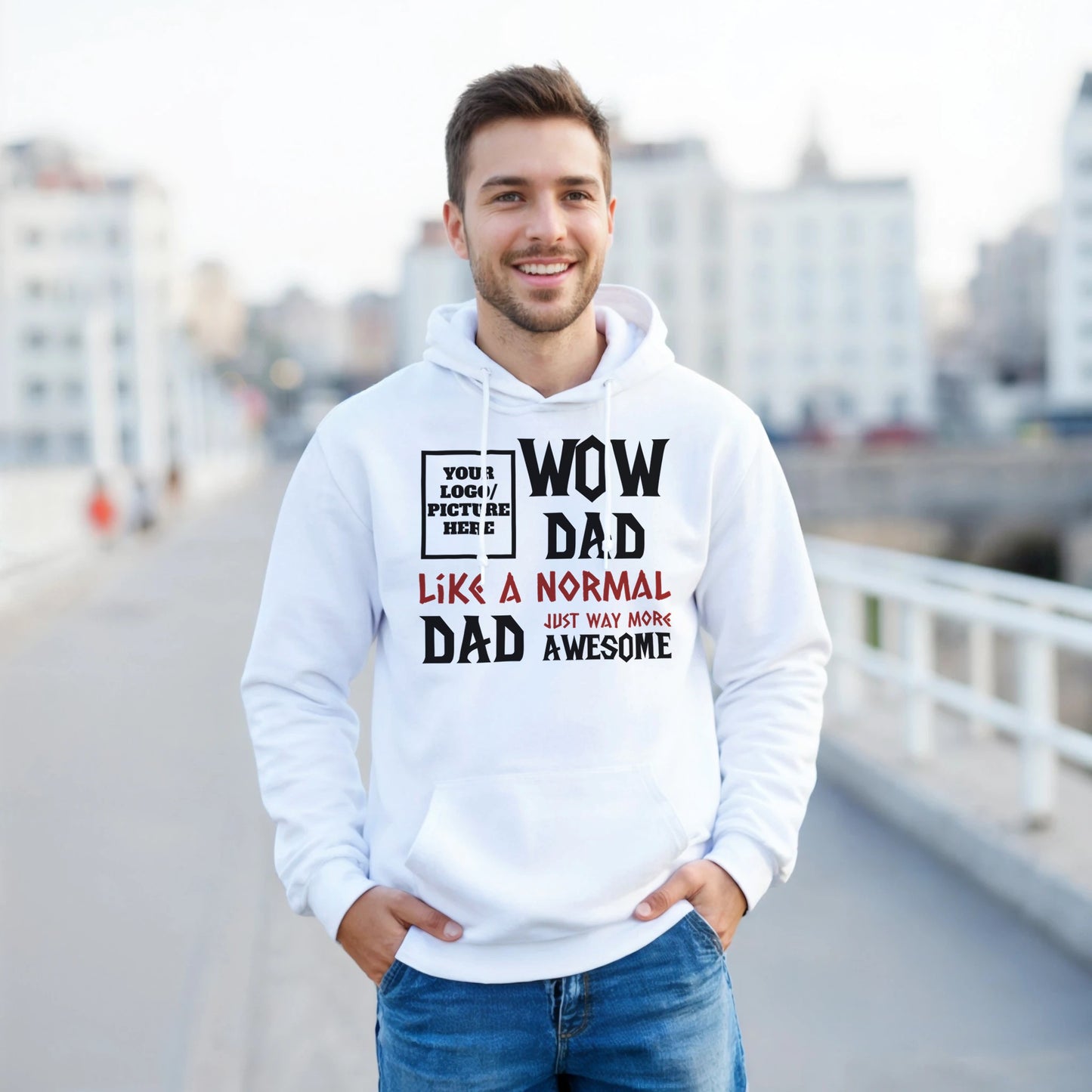 Man wearing a white hoodie with text, standing on a bridge with a cityscape background